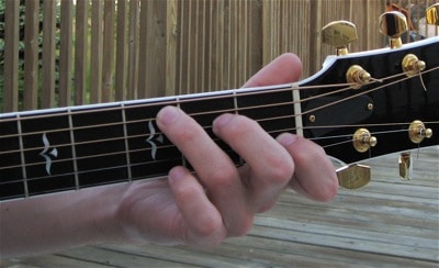 This is the wrong way to place your fingers on the guitar frets.